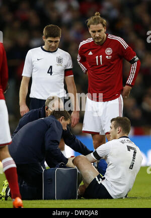 London, R) von Dänemark blickt auf eine während einer internationalen Fußball-freundlich-match zwischen Großbritannien und Dänemark im Wembley Stadion in London. 5. März 2014. Jack Wilshere(1st R) von England erhält medizinische Behandlung nach eine Verletzung als seine Teamkollegen Steven Gerrard(L) und Nicklas Bendtner(2nd, R) von Dänemark in einem internationalen Freundschaftsspiel zwischen England und Dänemark im Wembley Stadion in London, England am 5. März 2014 blickt auf. England gewann mit 1: 0. Bildnachweis: Wang Lili/Xinhua/Alamy Live-Nachrichten Stockfoto