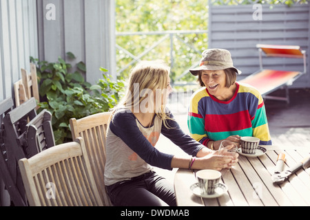 Großmutter und Enkelin Kaffeetrinken in Hof Stockfoto