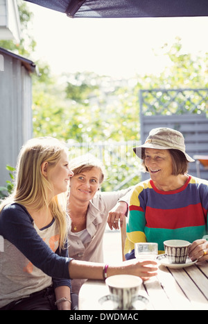 Drei Generationen Weibchen Kaffeetrinken in Hof Stockfoto