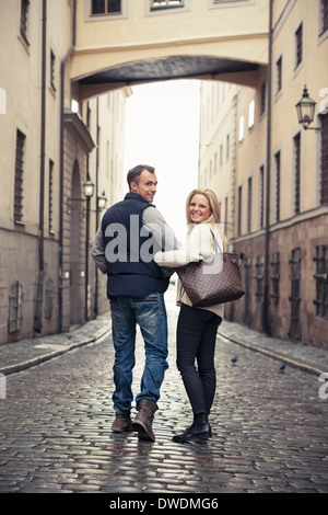 Volle Länge des glücklichen Paares zu Fuß auf Stadtstraße Stockfoto