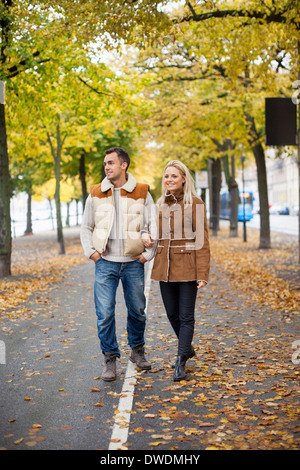 Volle Länge des jungen Paares gehen auf der Straße im Herbst Stockfoto