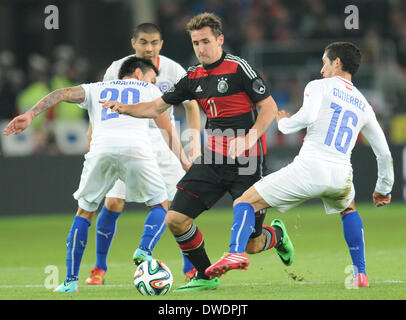 Stuttgart, Deutschland. 5. März 2014. Deutschlands Miroslav Klose (C) wetteifert um den Ball mit Charles Aranguiz (L) und Felipe Gutierrez Chiles während das internationale Freundschaftsspiel zwischen Deutschland und Chile bei Mercedes-Benz-Arena in Stuttgart, Deutschland, 5. März 2014. Foto: Andreas Gebert/Dpa/Alamy Live-Nachrichten Stockfoto