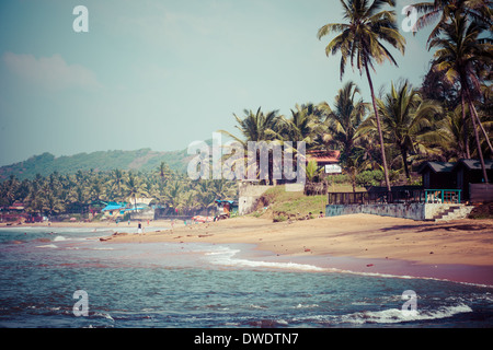 Beenden von Anjuna nass Panorama Strand bei Ebbe mit weißen Sand und grünen Kokospalmen, Goa, Indien Stockfoto