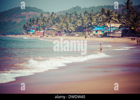 Beenden von Anjuna nass Panorama Strand bei Ebbe mit weißen Sand und grünen Kokospalmen, Goa, Indien Stockfoto