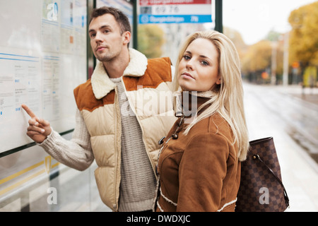 Junges Paar warten auf Bus stop Stockfoto