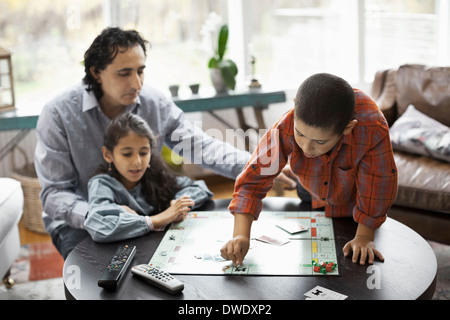 Vater und Kinder spielen Monopoly-Spiel im Wohnzimmer Stockfoto