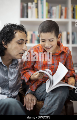 Vater Sohn bei den Hausaufgaben zu Hause unterstützen Stockfoto