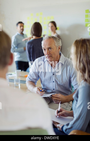 Unternehmer diskutieren mit Kollegen im Sitzungsraum Stockfoto