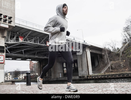 Voller Länge des Menschen Joggen auf der Straße Stockfoto