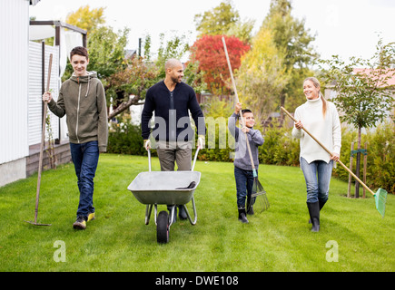 Vierköpfige Familie mit Gartengeräten Wandern in Hof Stockfoto