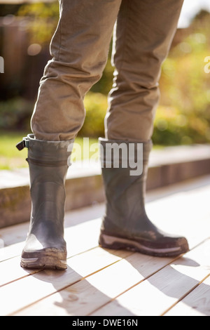 Geringen Teil der Mann in Latex Stiefel stehen am Hof Stockfoto