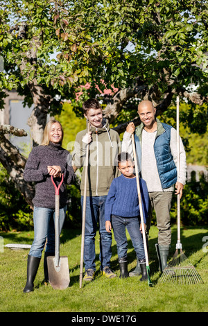 Porträt der Familie mit Gartengeräten am Hof stehen Stockfoto