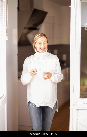 Glücklich Reife Frau mit Kaffeetasse, Haus zu verlassen Stockfoto