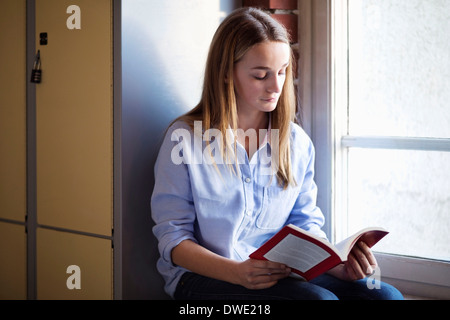 Schulmädchen Buch Fenster im Umkleideraum Stockfoto