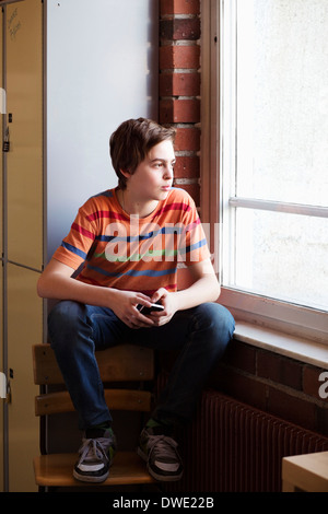 Nachdenkliche junge Blick durch Fenster in Umkleidekabine in der Schule Stockfoto