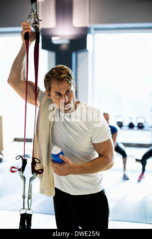 Müde Menschen mit Handtuch und Trinkflasche im Health club Stockfoto