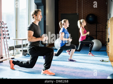 Kunden, die das Training mit Kettlebells in Turnhalle Stockfoto