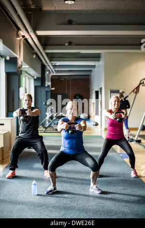 Voller Länge Freunde heben Kettlebells im Health club Stockfoto