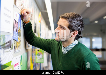 Männliche Schüler lesen Aushang in der Schule Stockfoto