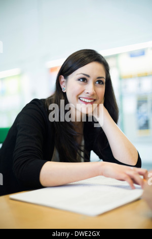 Glückliche Studentin am Tisch sitzen gemeinsam Zimmer Stockfoto