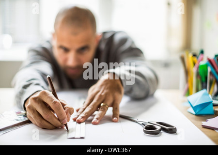 Reife Geschäftsmann zeichnen Linie auf dem Papier am Schalter in Kreativbüro Stockfoto