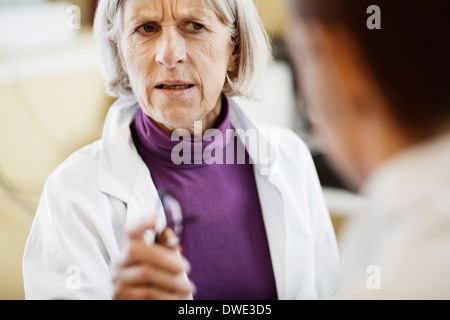 Leitende Ärztin, die ernsthafte Diskussion mit Kollegen im Krankenhaus Stockfoto