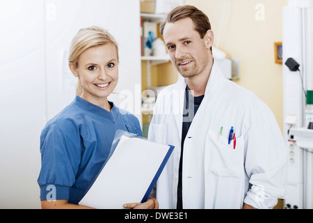 Porträt von zuversichtlich, Arzt und Krankenschwester mit Datei im Krankenhaus Stockfoto