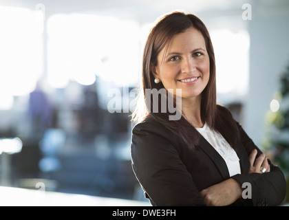 Porträt von zuversichtlich Geschäftsfrau stehend Arme gekreuzt im Büro Stockfoto