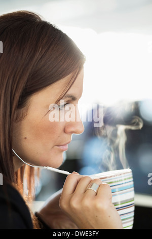 Geschäftsfrau, reden über Kopfhörer bei Kaffee im Büro Stockfoto