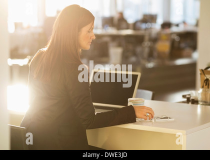 Geschäftsfrau, die am Schreibtisch im Büro Stockfoto