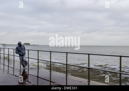 Mann in einem Sturm am Meer entlang läuft Stockfoto