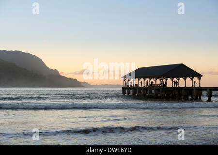 Hanalei Bay, Kauai, Hawaii, USA - Touristen auf Hanalei Pier im Morgengrauen mit der Na Pali-Bergen Stockfoto