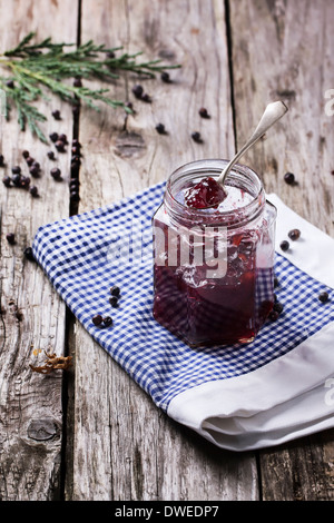 Glas mit Pflaume und Wacholder jam auf alten Holztisch Stockfoto