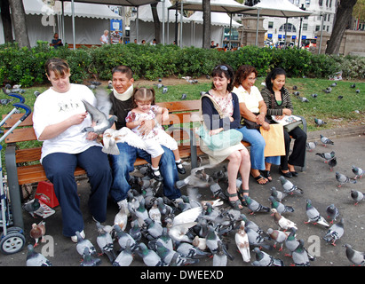 Touristen, die Fütterung der Tauben in der Plaza de Catalunya-Barcelona, Spanien Stockfoto