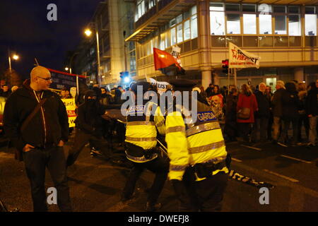 Dublin, Irland. 6. März 2014. Garda Offiziere (irische Polizei) zurückziehen, die Metall-Schranke. Die schwarz-Block Anarchisten und Garda Offiziere (irische Polizei) ziehen an die Metall-Schranke. Kleine Schlägereien brach zwischen Gardai (irische Polizei) und Demonstranten, nachdem ein Block von schwarzen Block Anarchisten versucht, die Polizeiabsperrung durchbrechen. Zwei Demonstranten wurden verhaftet. Bildnachweis: Michael Debets/Alamy Live-Nachrichten Stockfoto