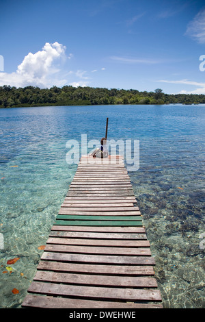 Einsamer Ort sitzt auf Dock am Marovo Lagune, Salomon-Inseln, Süd-Pazifik Stockfoto