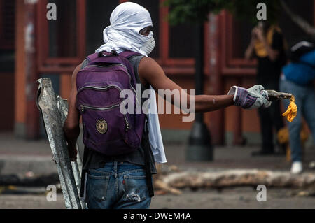 Caracas, Venezuela. 6. März 2014. Ein Demonstrant hält einen Gegenstand während einer Protestaktion in Altamira in der Gemeinde von Chacao, östlich von Caracas, Venezuela, am 6. März 2014. Ein National Gardist Offizier und ein Zivilist starb Donnerstag bei Zusammenstößen in der venezolanischen Hauptstadt Caracas. Bildnachweis: Boris Vergara/Xinhua/Alamy Live-Nachrichten Stockfoto