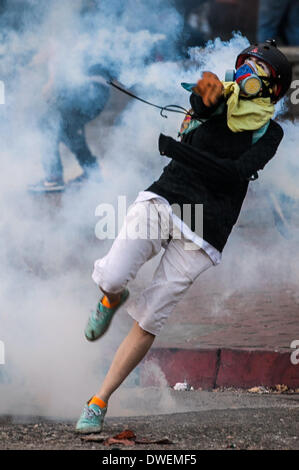 Caracas, Venezuela. 6. März 2014. Ein Demonstrant wirft ein Objekt während einer Protestaktion in Altamira, im Gemeindegebiet von Chacao, östlich von Caracas, Venezuela, am 6. März 2014. Ein National Gardist Offizier und ein Zivilist starb Donnerstag bei Zusammenstößen in der venezolanischen Hauptstadt Caracas. Bildnachweis: Boris Vergara/Xinhua/Alamy Live-Nachrichten Stockfoto