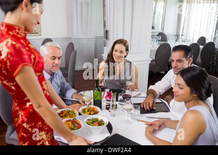 Kellnerin, die Speisen zu Kollegen am Tisch im restaurant Stockfoto