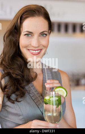 Lächelnde junge Frau mit Cocktailglas Stockfoto