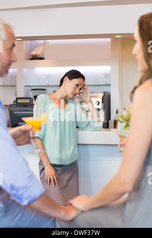 Beschnitten, paar Toasten Cocktails mit Frau im Hintergrund Stockfoto