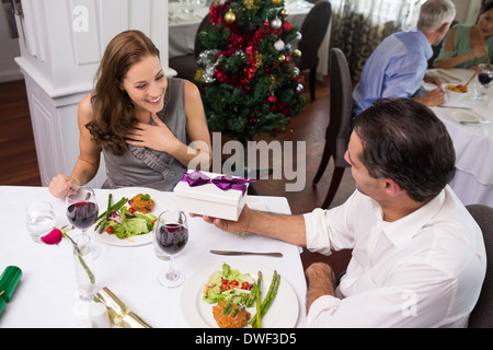 Mann mit Geschenk-Box, lächelnde Frau im restaurant Stockfoto