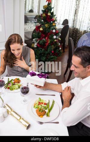 Mann mit Geschenk-Box, lächelnde Frau im restaurant Stockfoto