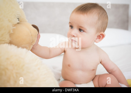Baby Junge spielt mit Stofftier Stockfoto