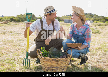 Lächelnde paar mit Gemüse im Feld Stockfoto