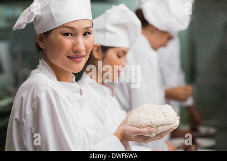 Happy Chef Teig lächelnd in die Kamera halten Stockfoto