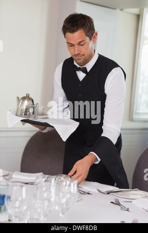Kellner mit Tablett und Einstellung Tabelle Stockfoto