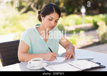 Ernsthafte Geschäftsfrau mit Kaffee und planen ihre Woche Stockfoto