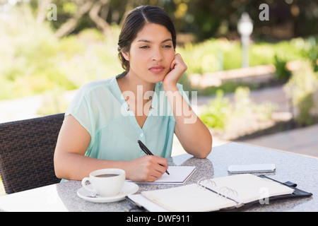 Ernsthafte Geschäftsfrau mit Kaffee und planen ihre Woche Stockfoto