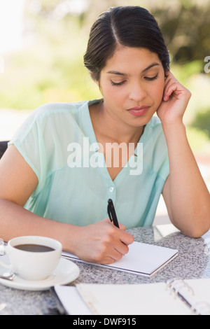 Ernsthafte Geschäftsfrau mit Kaffee und planen ihre Woche Stockfoto
